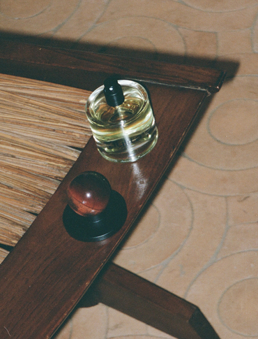Agati bottle with cap sitting on a rustic chair, artistically photographed on film